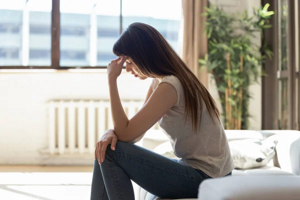 Unhappy young attractive woman holding forehead side view, suffering. — Stock Photo, Image