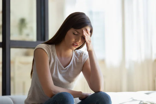 Giovane donna attraente infelice tenendo la fronte da vicino, soffrendo . — Foto Stock