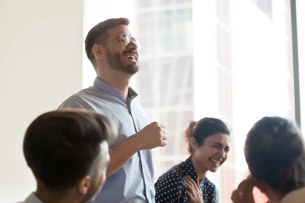 Equipo corporativo multiétnico riendo durante la sesión informativa en la oficina —  Fotos de Stock