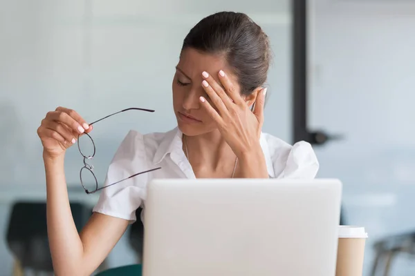 Mulher milenar tirando óculos cansados de trabalho de computador — Fotografia de Stock