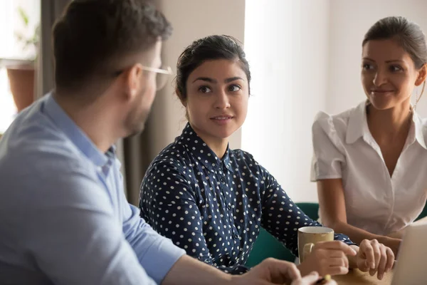 Compañeros multiétnicos se sientan en el lugar de trabajo discuten momentos de trabajo actuales — Foto de Stock