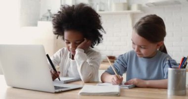 Melez kökenli şirin okul kızları evde birlikte okuyorlar.