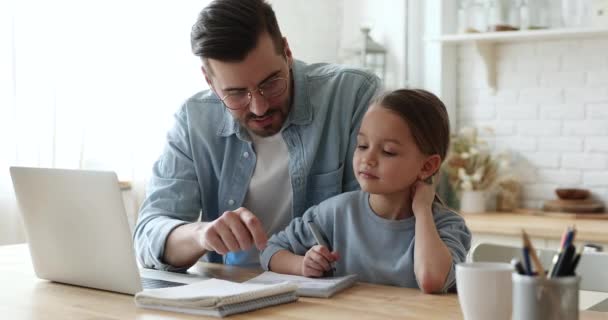 Padre joven explicando tareas ayudando a niña con estudios — Vídeo de stock