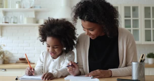 Mutlu Afrikalı anne ve kız evde kalem çiziyor. — Stok video