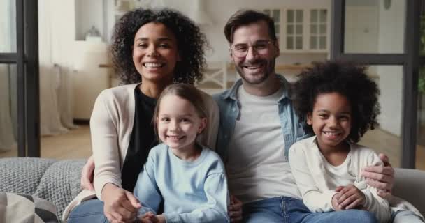 Vrolijke interraciale familie diverse etniciteit ouders kietelen kinderen thuis — Stockvideo