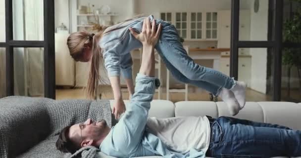 사랑하는 아빠가 귀여운 아이를 들어올려 집에서 딸 과놀게하는 모습 — 비디오