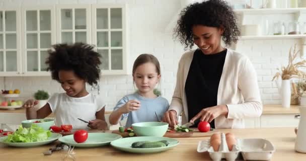 Usmívající se africká matka výuka smíšené rasy děti příprava čerstvého salátu — Stock video