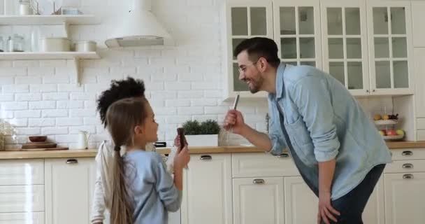 Padre y dos niños de raza mixta bailando cantando en la cocina — Vídeos de Stock