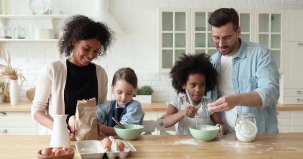Szczęśliwy mieszane wyścig cute dzieci pomagając młodym rodzicom co ciasto — Wideo stockowe