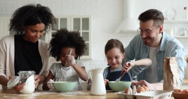Mieszane dzieci pochodzenia etnicznego przygotowujące naleśniki pomagające rodzicom gotować razem — Wideo stockowe