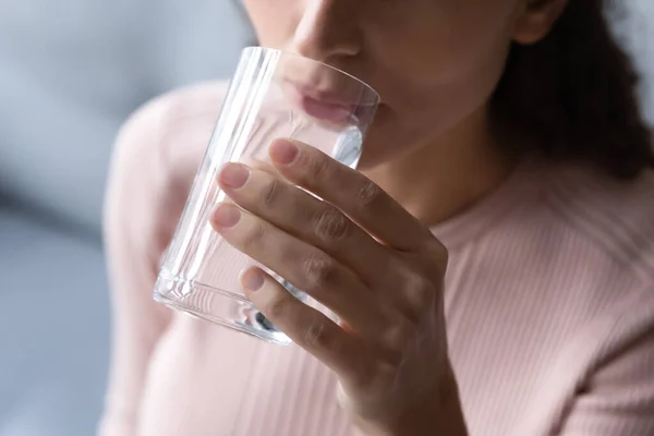 Close up focus millennial female drinking pure water.