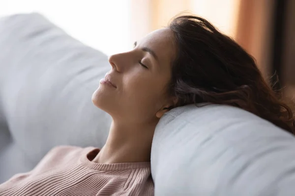 Tranquil peaceful young woman sleeping on sofa.