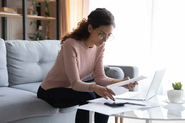 Gericht jonge vrouw in bril beheren van maandelijkse budget. — Stockfoto