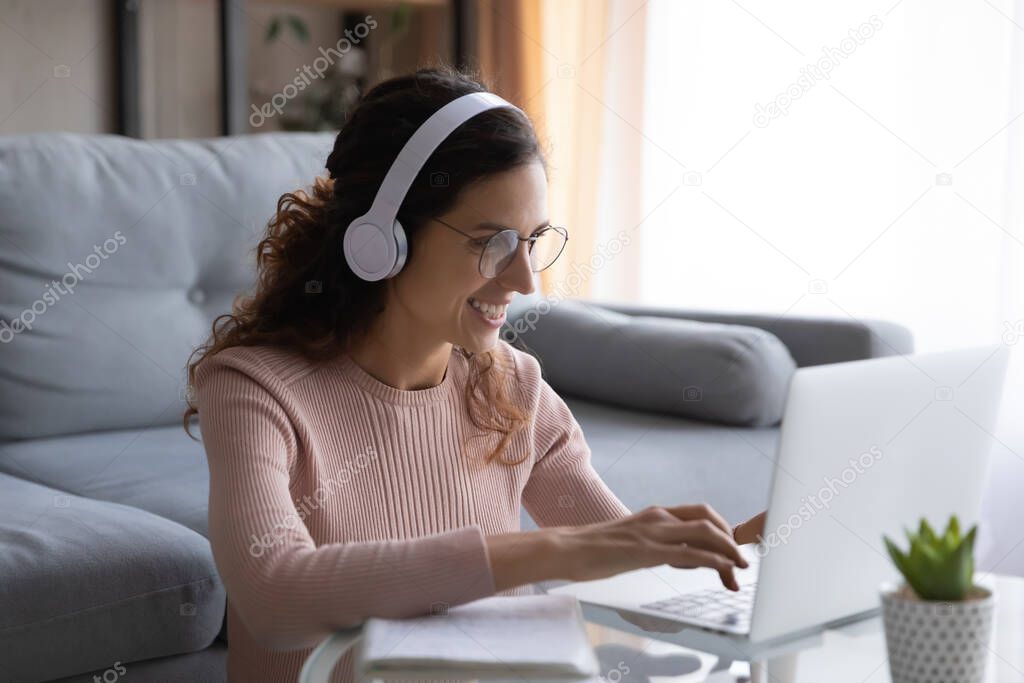 Happy millennial woman student in glasses studying on online courses.