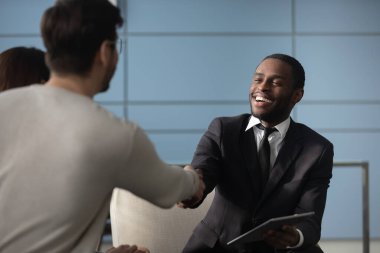 Yakışıklı Afro-Amerikan iş adamı takım elbiseli, insanlarla el sıkışıyor..