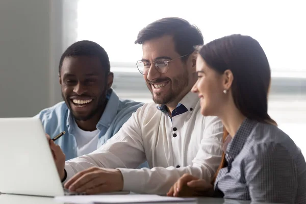 Diverso hombre de negocios y mujer de negocios riendo mirando la pantalla del ordenador portátil . — Foto de Stock