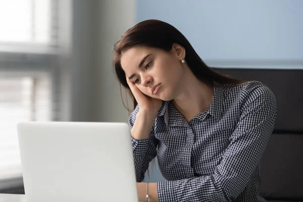 Trött ung affärskvinna funderar på arbetsproblem på laptop. — Stockfoto