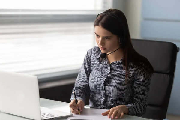 Attractive businesswoman talking using headphones signing up document. — Stock Photo, Image