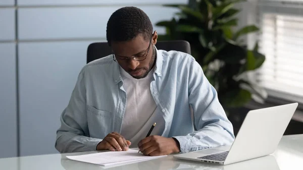 Empresario afroamericano enfocado escribiendo documento en papel de firma . —  Fotos de Stock