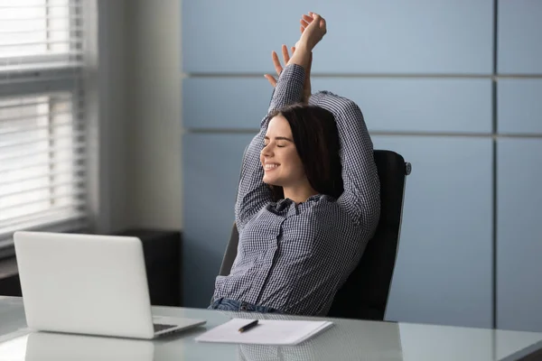 Happy businesswoman with hands behind head relaxing in comfortable office. — Stock Photo, Image