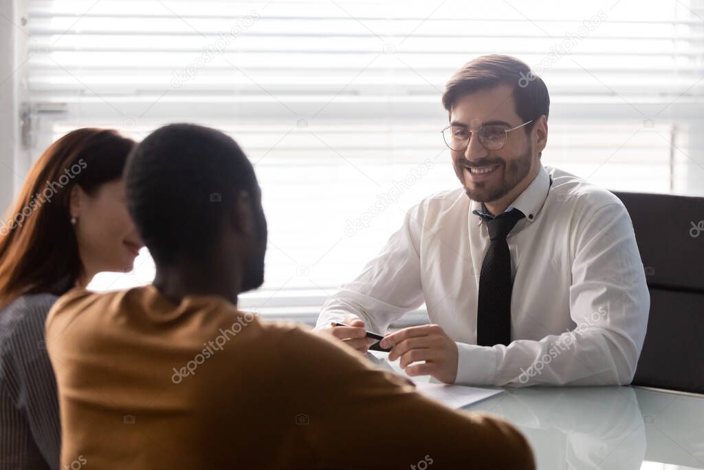 Young smiling businessman with diverse customer at negotiation.
