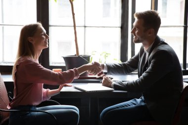 Gülümseyen kadın tokalaşması erkek danışmanla tanışır.