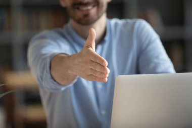 Gülümseyen dost canlısı iş adamı el sıkışmak için elini uzatıyor.