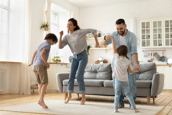 Jeune couple marié excité dansant avec de petits enfants ludiques . — Photo