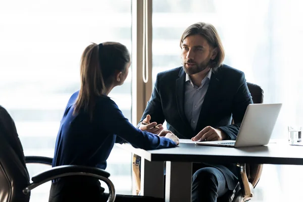 Líder de empresário confiante dando instruções para mulher de negócios na reunião — Fotografia de Stock