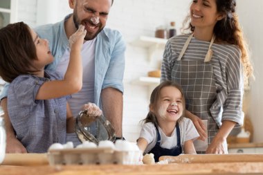 Neşeli küçük kardeşler gülen ebeveynlere un saçıyor..