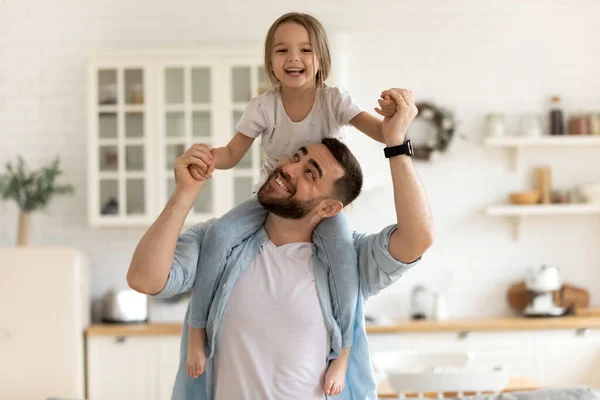 Fröhlicher Papa trägt am Hals glückliche kleine Tochter. — Stockfoto