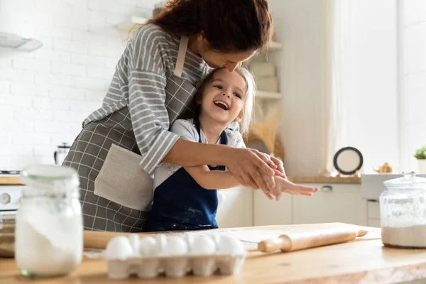 Gelukkig schattig klein kind meisje genieten koken met moeder. — Stockfoto