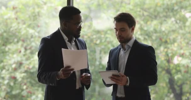 Deux hommes d'affaires multiethniques discutant de questions de travail dans un bureau moderne . — Video