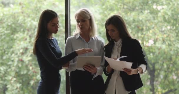 Jovens colegas consultando com líder feminina madura no espaço de trabalho . — Vídeo de Stock