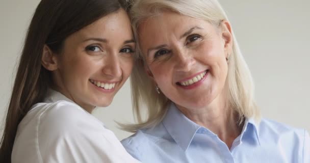 Headshot close-up gelukkig twee generaties zakenvrouwen op zoek naar camera. — Stockvideo