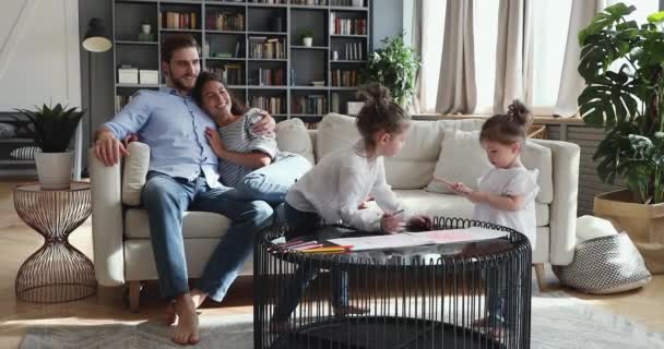 Padres y dos hijos pasando el fin de semana en la sala de estar juntos — Vídeo de stock