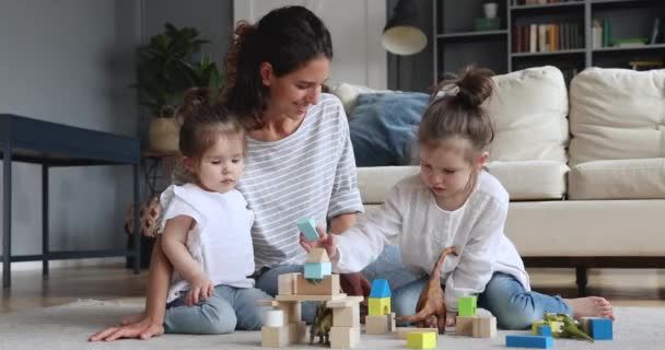 Ευτυχισμένη νταντά μητέρα παίζει με τα παιδιά στο πάτωμα στο σπίτι — Αρχείο Βίντεο