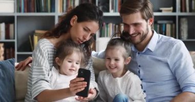 Mutlu ebeveynler çocuklara akıllı telefon kullanarak komik uygulamalar öğretiyor.