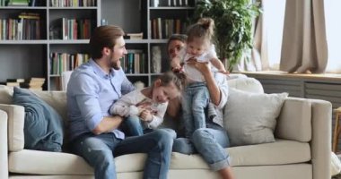 Neşeli aile birlikte vakit geçirir. Kanepede gıdıklanarak eğlenir.