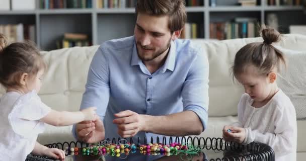 Feliz padre joven y cariñoso jugando con hijas lindas en casa — Vídeos de Stock