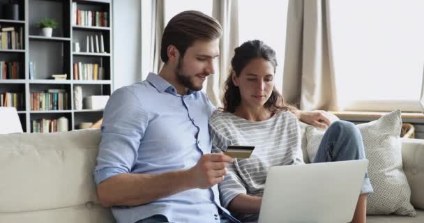 Ευτυχείς πελάτες ζευγάρι που κατέχουν πιστωτική κάρτα αγοράζουν online χρησιμοποιώντας φορητό υπολογιστή — Αρχείο Βίντεο