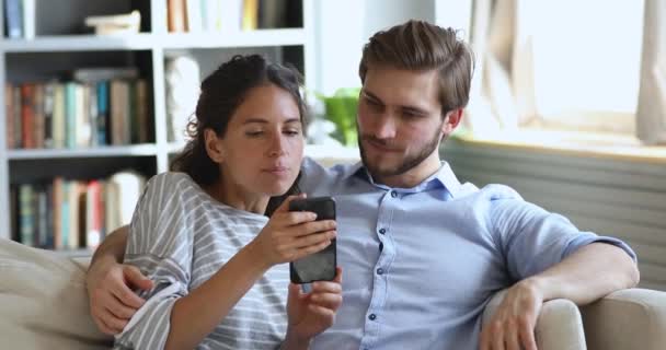 Overjoyed jovem casal olhando para smartphone ganhando presente ou prêmio — Vídeo de Stock