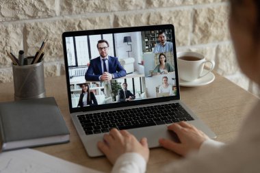 Erkek çalışan çeşitli meslektaşlarıyla görüntülü konuşma yapıyor