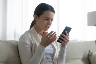 Cep telefonu sorunu yüzünden hayal kırıklığına uğramış mutsuz genç bir kadın.