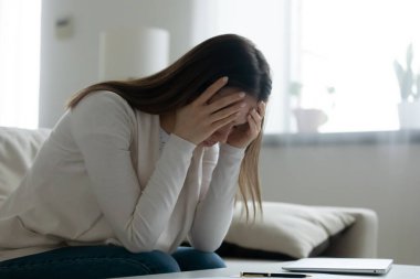 Düşüncelere dalmış, sıkıntılı genç bir kadın.