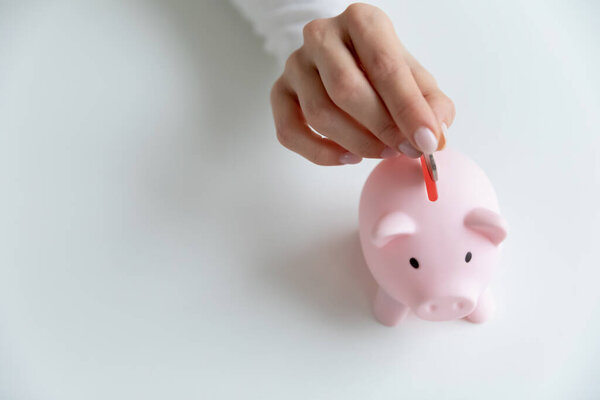 Woman put coin in piggy bank saving money