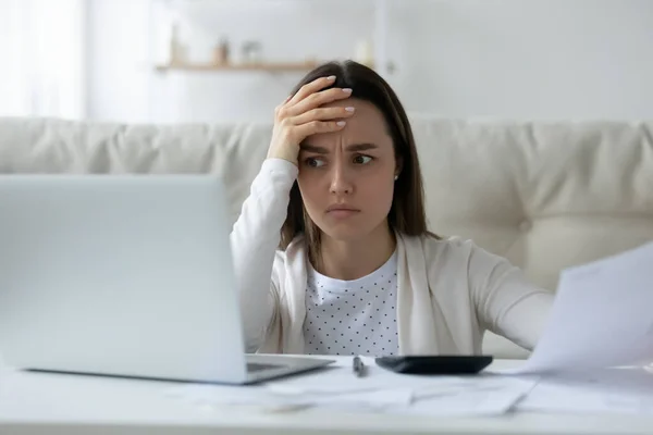 Jovem confuso tem problemas para pagar contas online — Fotografia de Stock