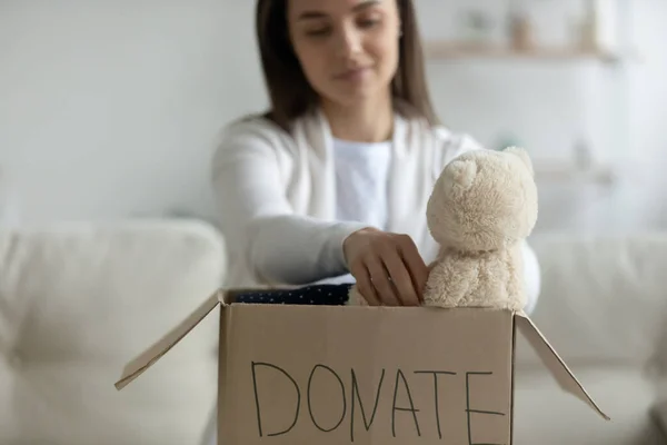 Mujer joven reúne cosas para la donación o la caridad —  Fotos de Stock