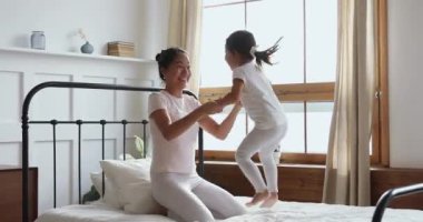 Mutlu Asyalı bebek bakıcısı yatak odasında çocukla eğleniyor..