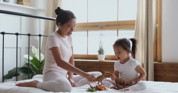 Mooie aziatische etniciteit jonge vrouw spelen speelgoed met kleine dochter. — Stockvideo